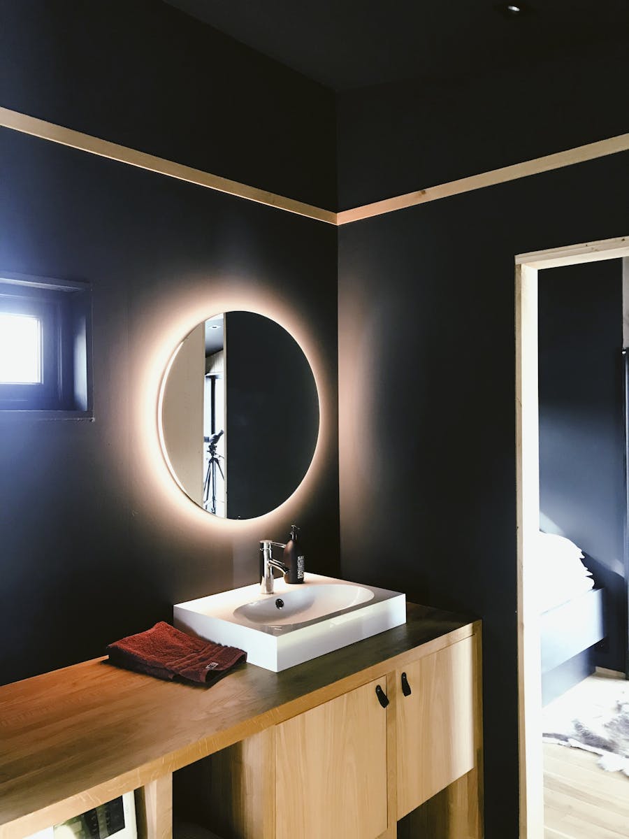 Reforma de baño moderno con muebles de madera en Oviedo